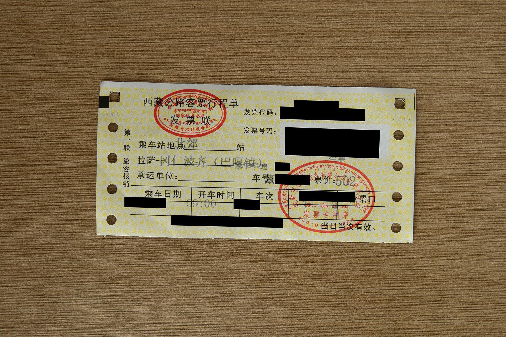 Yellow and white bus ticket from Lhasa to Mount Kailash, Baga, priced at 502, with Chinese and Tibetan text and red stamps.